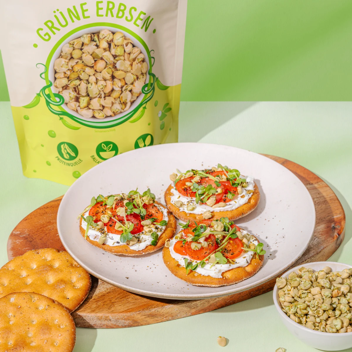 Billedet viser grønne ærteflager som topping på kiks med salatbund.