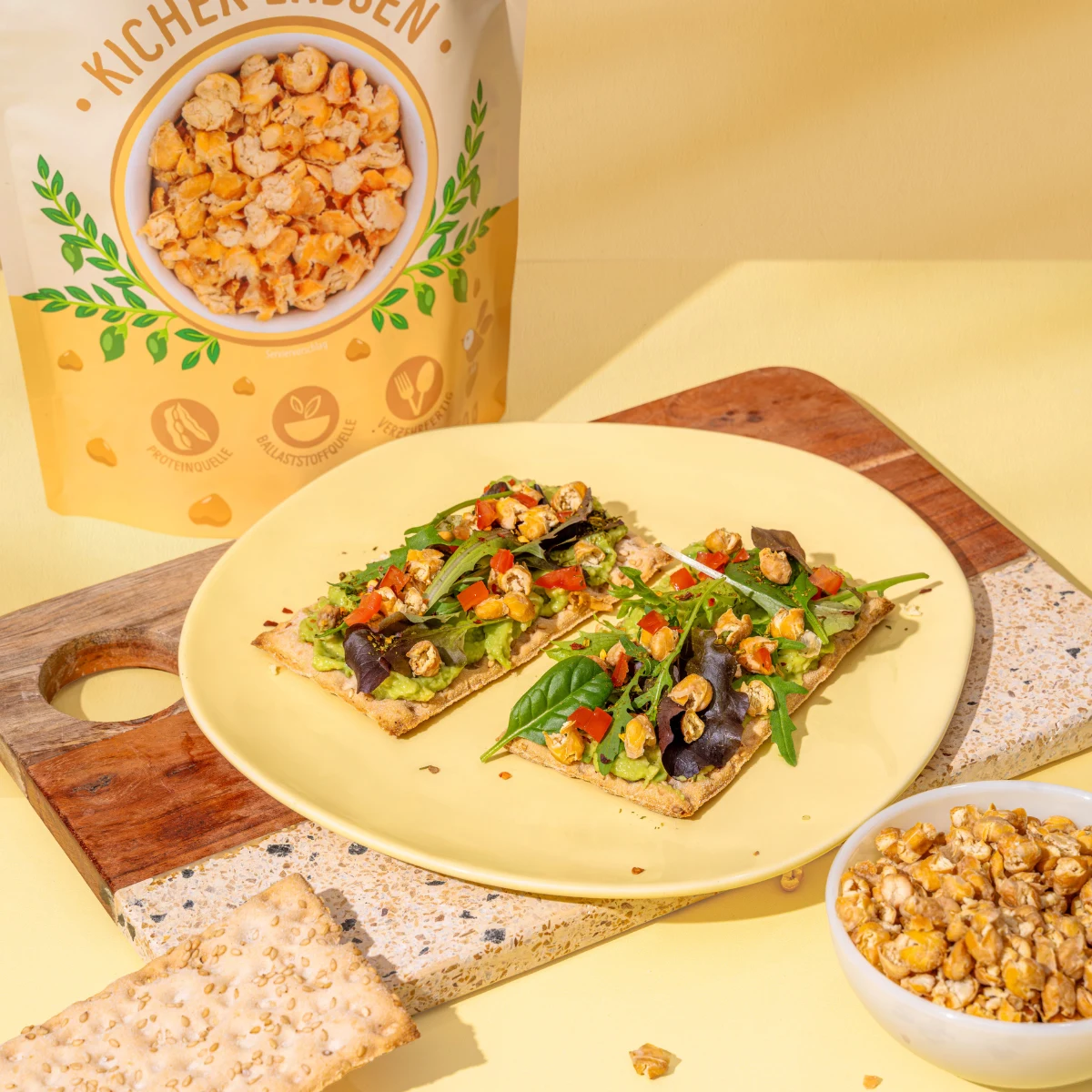 Billedet viser sprøde kikærteflager som topping på knækbrød med salat.