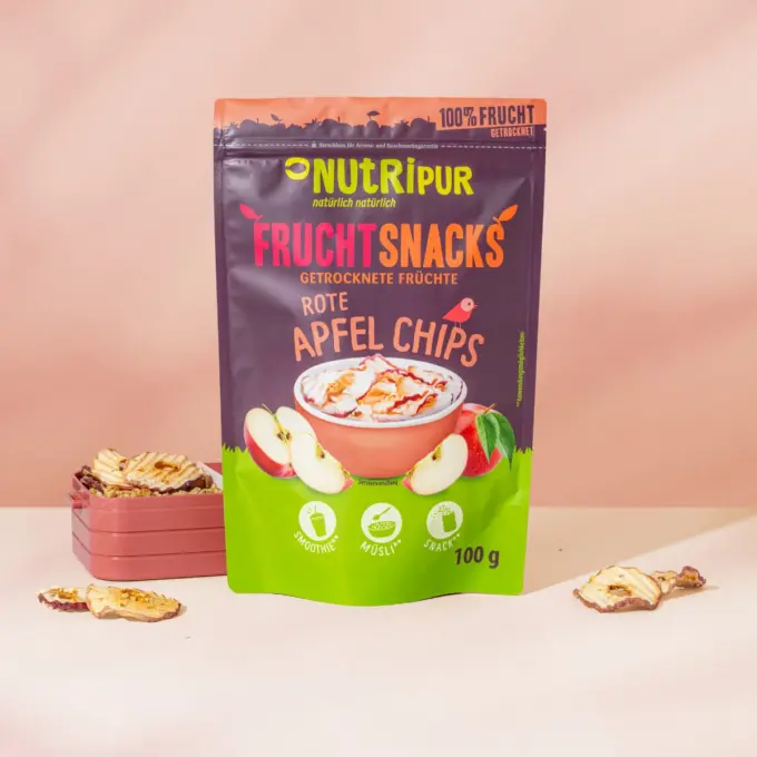 Billedet viser i front emballagen med en madkasse samt æblechips bagved