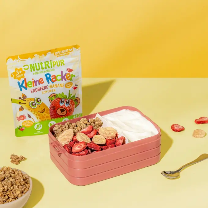 Billedet viser de “Lille Spilopmager Jordbær-Banan” fra Nutripur med yoghurt og flager som skolemad i en madkasse.